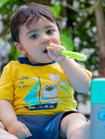 A toddler trying to self-feed using a spoon